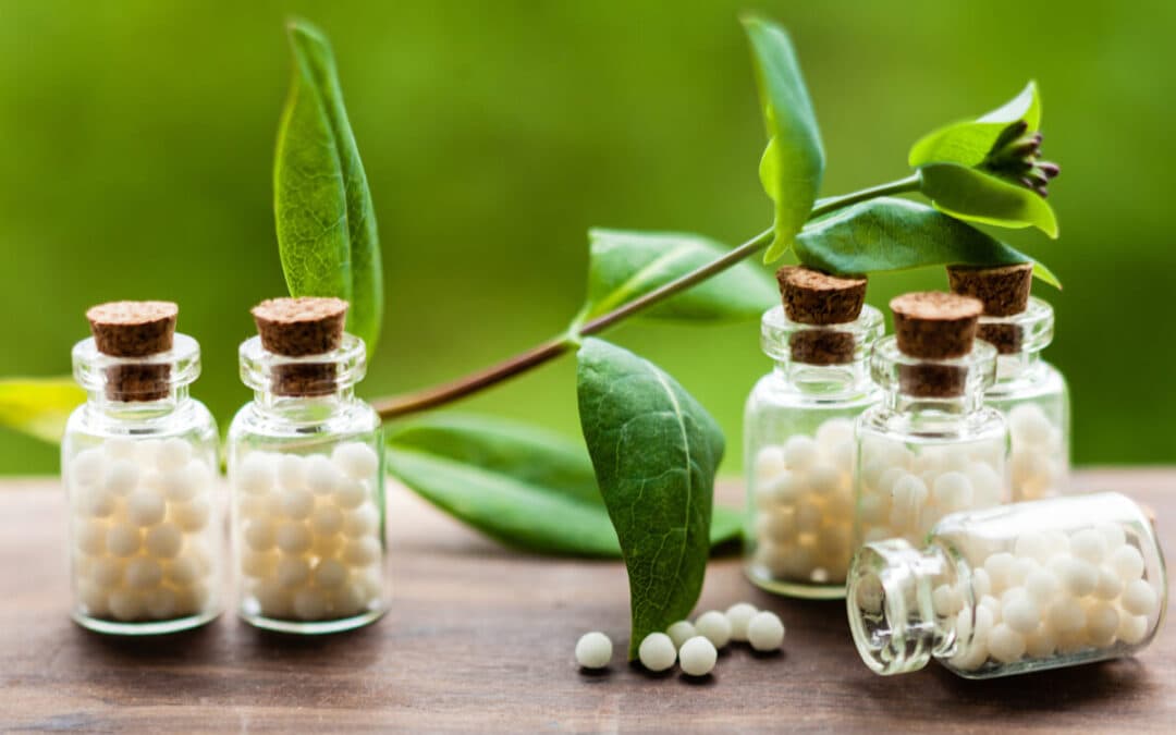 Small homeopathic medicine bottles with green leaves