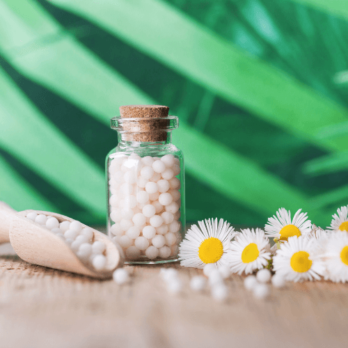 Homeopathic medicine bottle, pellets and flowers